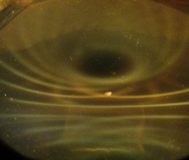 Below: Deep image views at a steep angle of a cube magnet on left, and a disk magnet on the right. Notice the centripetal ‘bloom’ hypotrochoid that has amazing holographic depth out of a mere micron of ferrofluid!