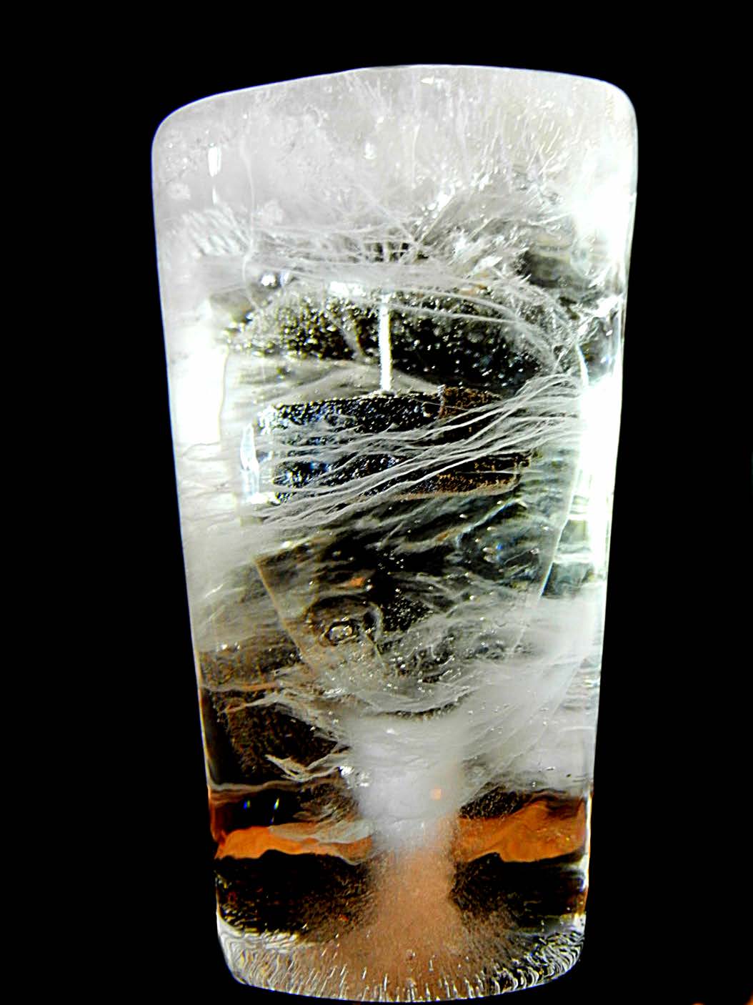 Transparent resin block containing a vertical wire and branching white discharge tracks around stacked dark discs.
