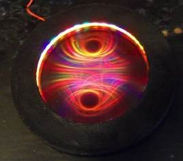 Small circular Ferrocell glowing red and violet, with two symmetrical oval field patterns.