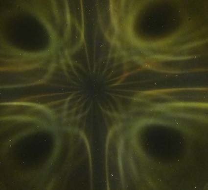 Below: ½” cylinder magnet along one pole on the left, and two of the same cylinder magnets on the right connected along their non-polarized sides. Notice the voidance pattern in the middle between these four poles.