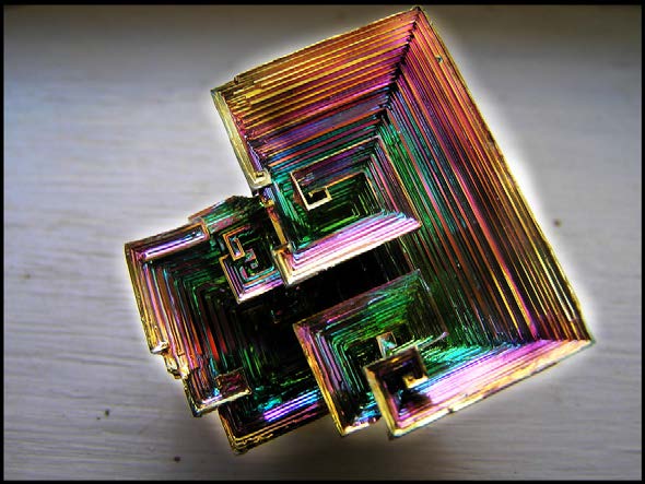 Top view of an iridescent bismuth hopper crystal with stepped square growth.