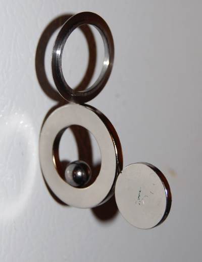 Below: Left is a 5/8” neodymium with a disk magnet in parallel to the 5/8” dielectric inertial plane, also a steel ring sitting perpendicular to the dielectric inertial plane. Middle picture, steel disk perpendicular to 
