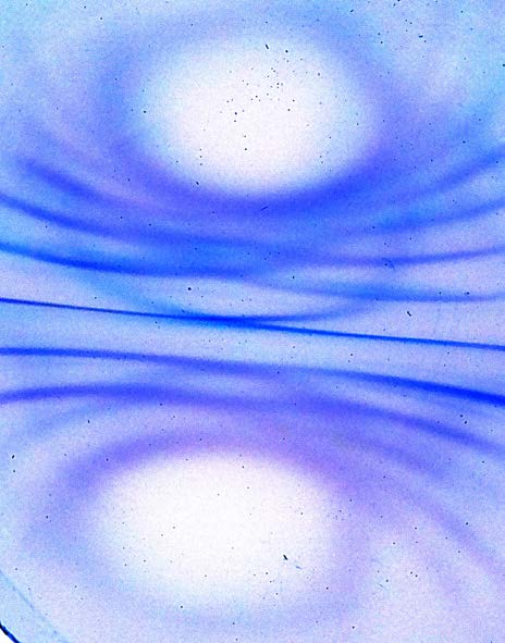 Below: Cube magnet under ferrocell. Image on left has been inverted. Showing polarity top and bottom. Notice the radial compression and voidance of the light along the dielectric inertial planes of the magnet.