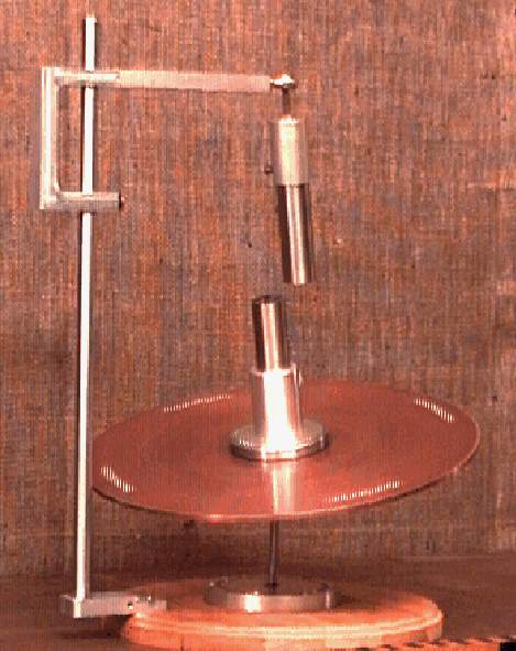A suspended magnet above a spinning disk apparatus used to demonstrate precession.