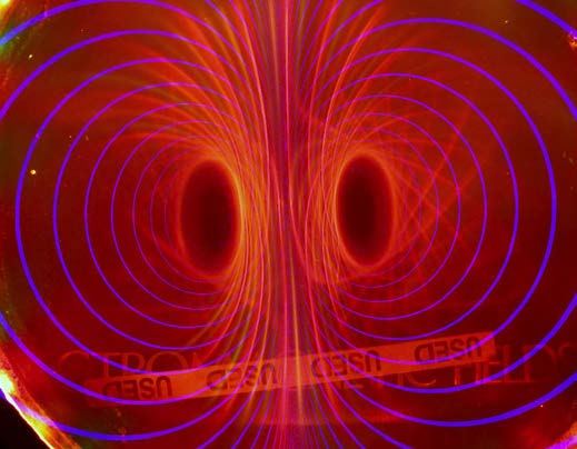 Below: [Photo courtesy of Michael Snyder of revolution-labs.com] Image on left you see a cube magnet looking corner-on behind the Timm Vanderelli ferrocell. Notice the depressed bowl shape formation along the faces of th