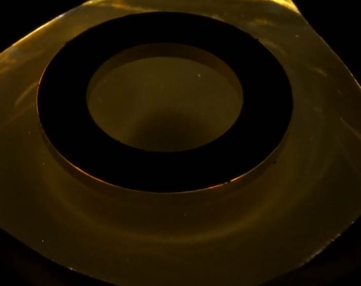 Below: A torus of light as seen between a ferrocell in which two magnets are undergoing dielectric spatial voidance. Comprehension of why there is a shrinking sphere of light rather than a radial collapse is of utmost im