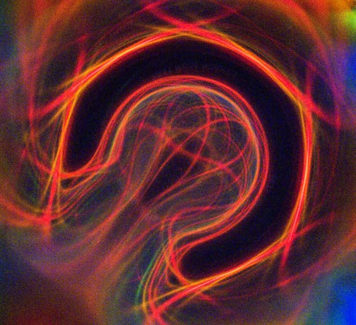Abstract red, orange, and green Ferrocell light pattern with looping arcs.