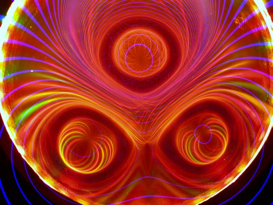 Circular Ferrocell image in red, gold, and violet, with three vortex-like lobes.