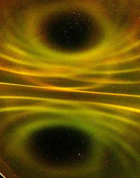 Below: Cube magnet under ferrocell. Image on left has been inverted. Showing polarity top and bottom. Notice the radial compression and voidance of the light along the dielectric inertial planes of the magnet.